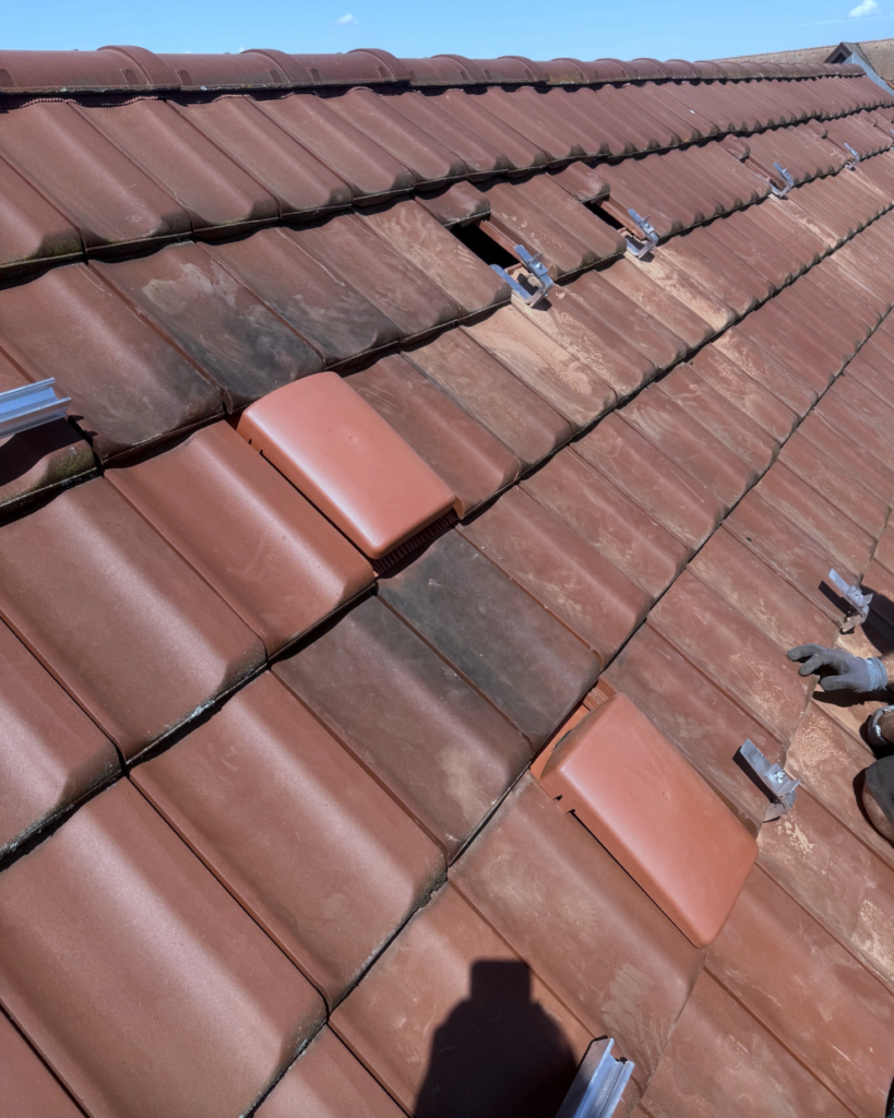Vorbereitete Dachfläche mit montierten Dachhaken und geöffneten Dachziegeln für die PV-Unterkonstruktion