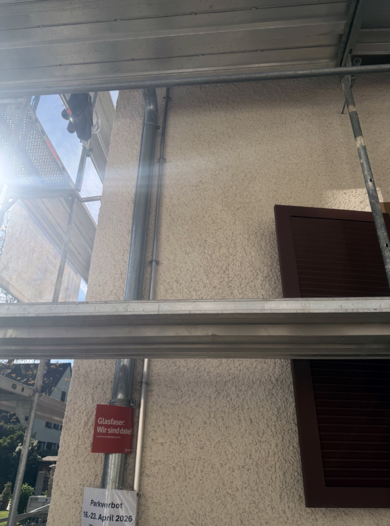 Montageschienen und Gerüst an der Hausfassade während der Photovoltaik-Installation