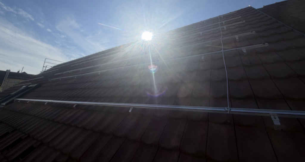 Dachfläche mit PV-Unterkonstruktion und Sonneneinstrahlung während der Montagearbeiten