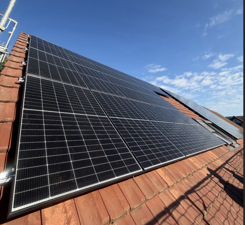 Fertiggestellte Photovoltaikanlage mit mehreren Modulen auf einem roten Ziegeldach