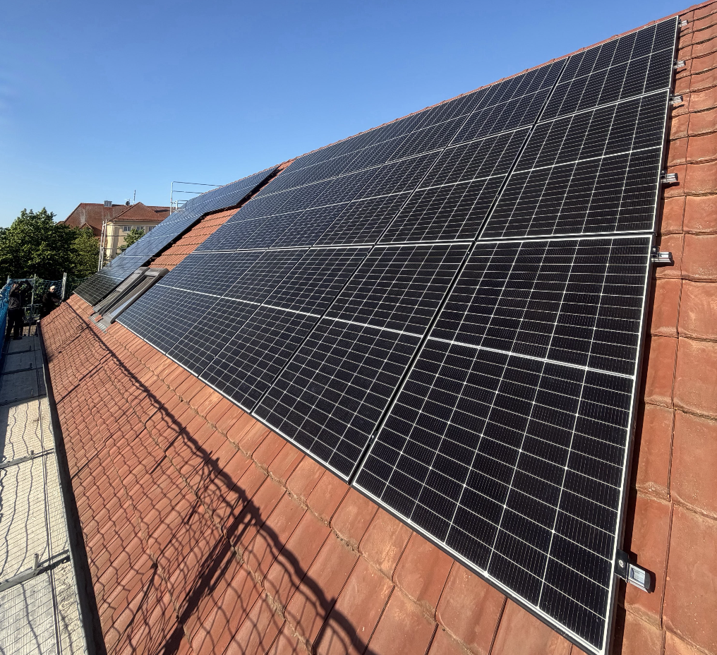 Fertiggestellte Photovoltaikanlage mit mehreren Modulen auf einem roten Ziegeldach